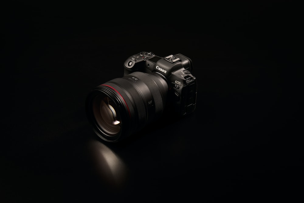 câmera preta nikon dslr na superfície preta
