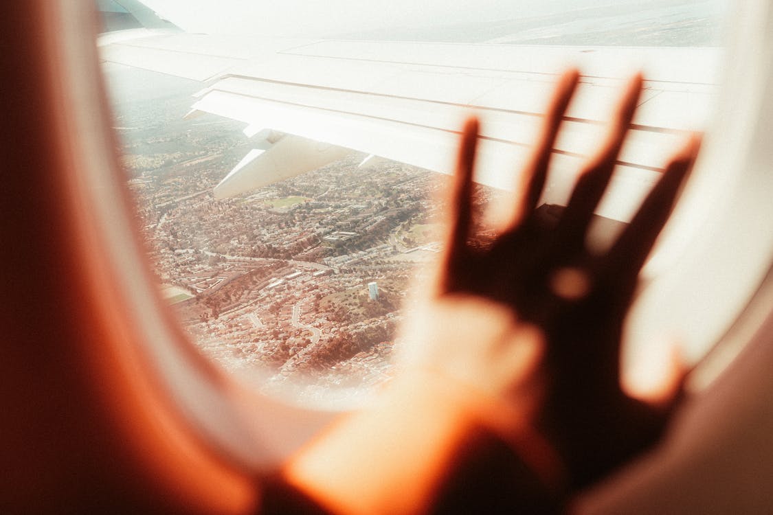 Free Persons Hand on Airplane Window Stock Photo