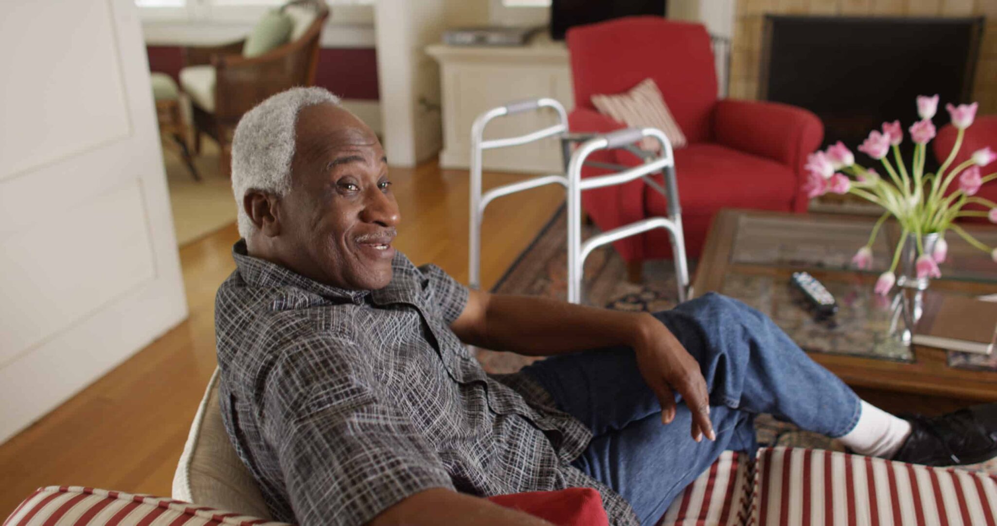 Retired African man relaxed and talking on his couch