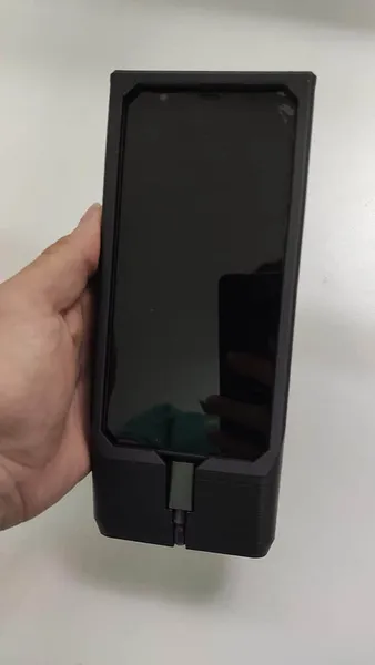 Prototipo funcional de carcasa negra impresa en 3D con lector integrado, sostenido en la mano