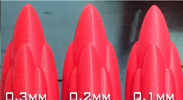 Tres piezas rojas iguales impresas a 0.3, 0.2 y 0.1 mm de altura de capa para comparar acabado