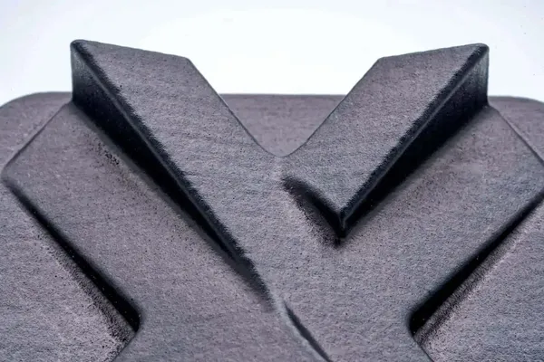 Acercamiento a la superficie texturizada de una pieza impresa en 3D, mostrando el nivel de acabado