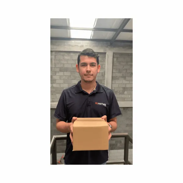 Integrante del equipo de 3DPartner con playera de la marca sosteniendo una caja de pedido lista para envío