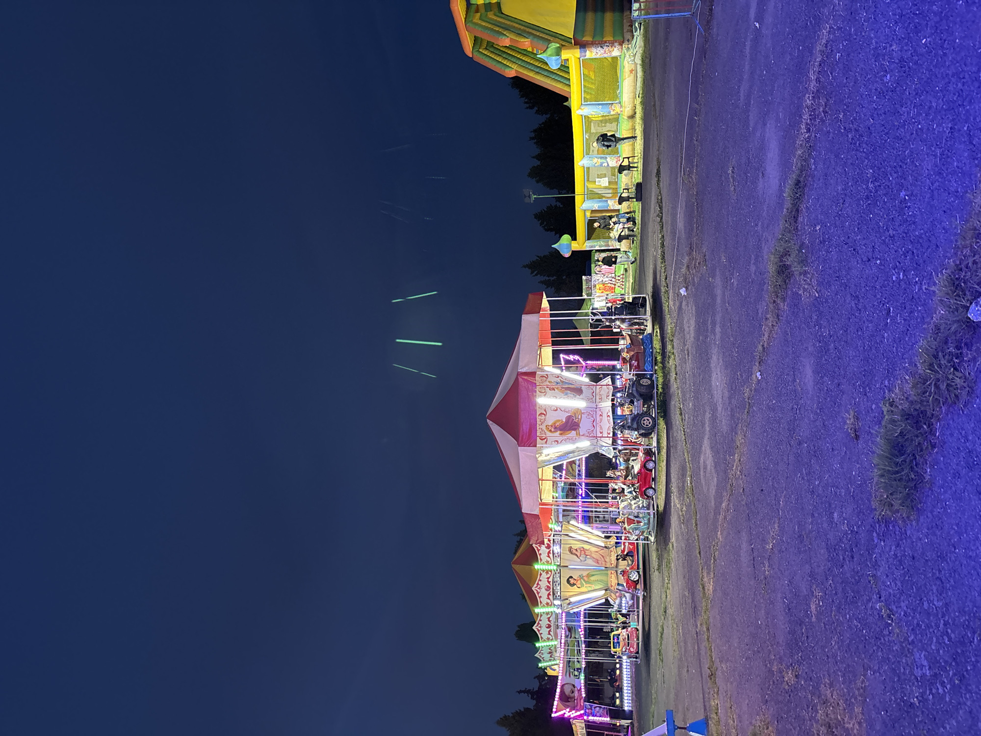Evening carnival operates in Pomorie, Bulgaria with illuminated rides