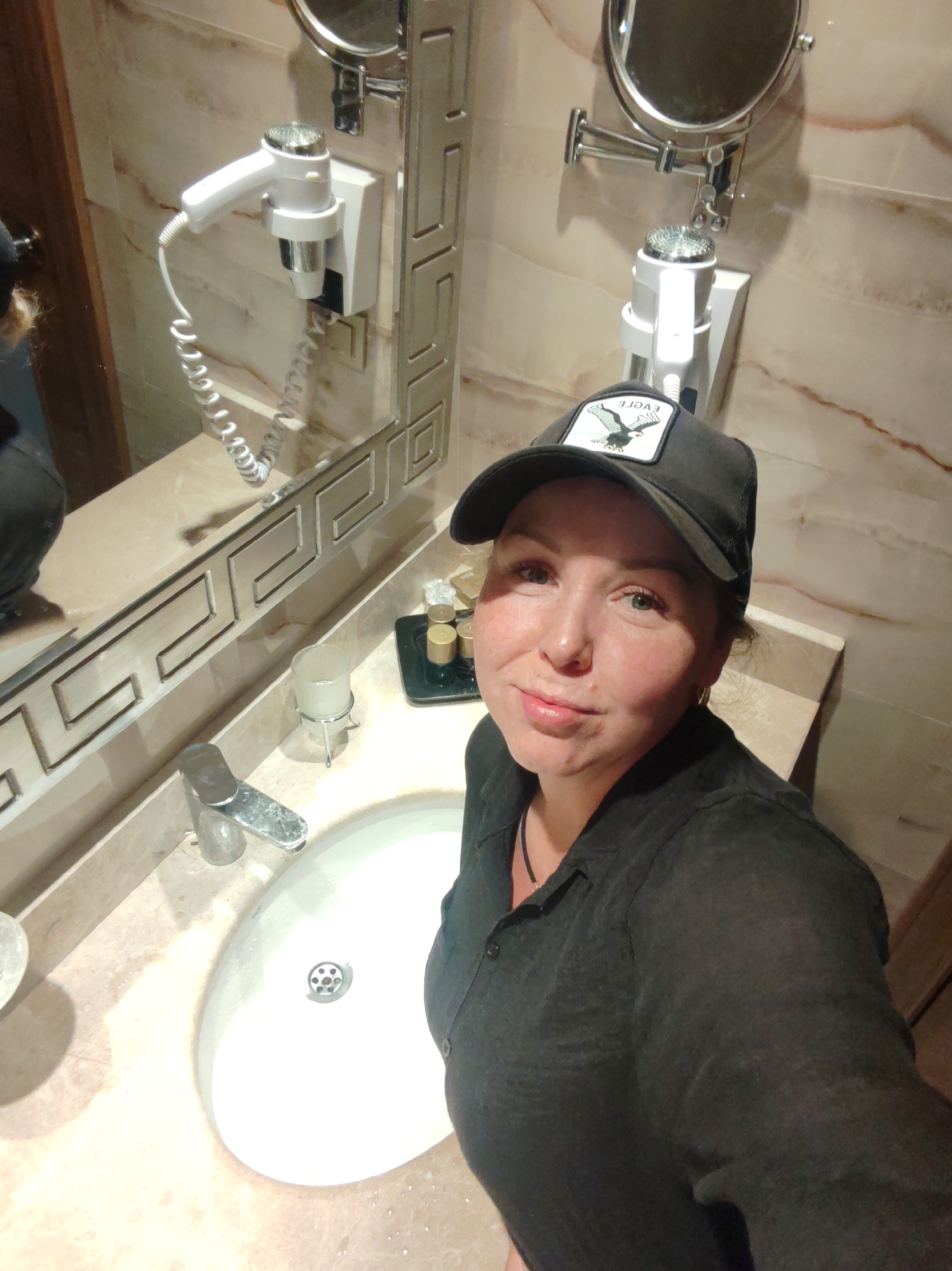 Woman takes bathroom selfie in marble-appointed restroom