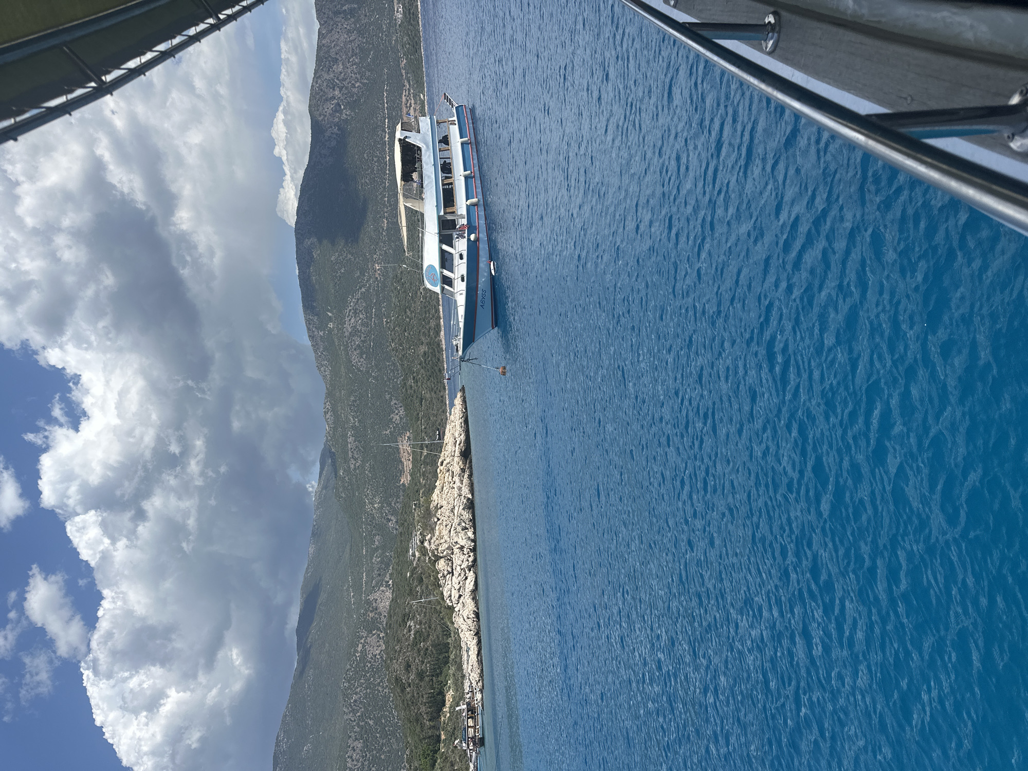 Peaceful coastal boating scene documented near rocky shoreline