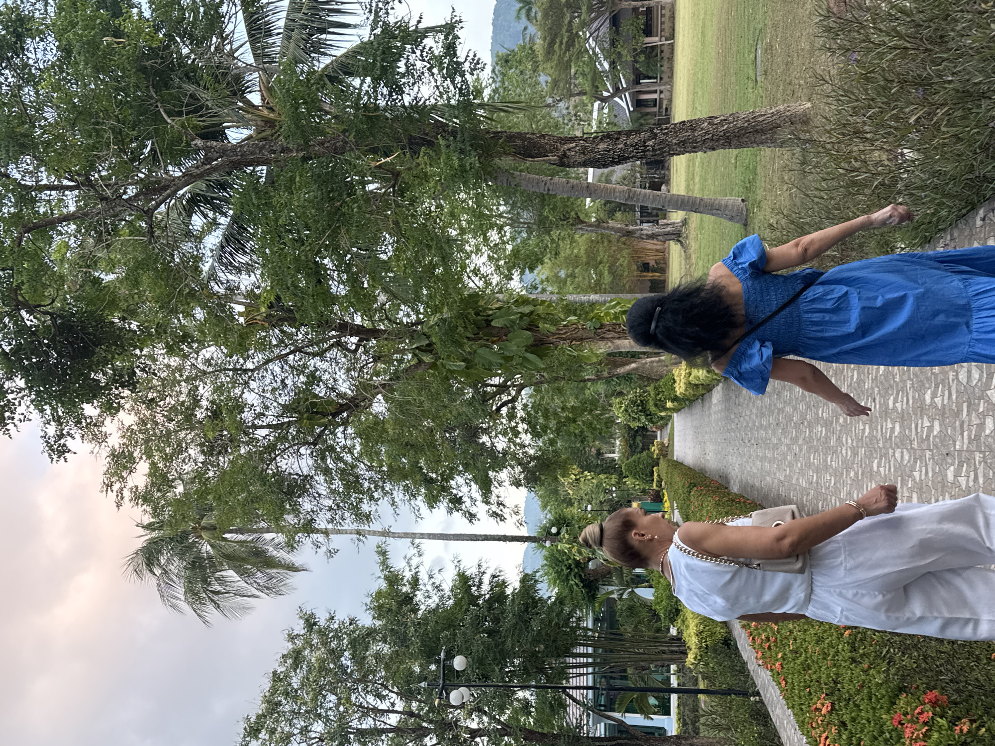 Two women stroll through scenic park in Patong, Thailand