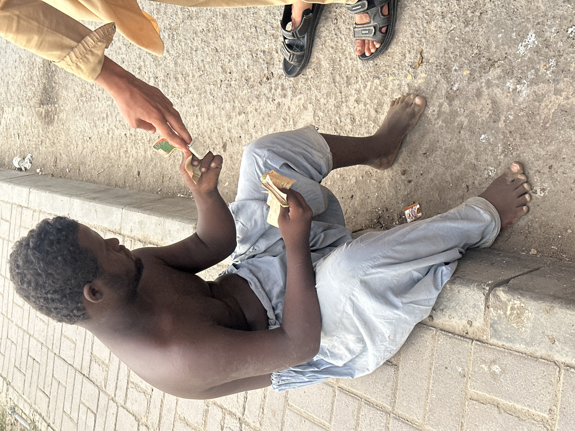 Cash exchange and pigeons on a Karachi street