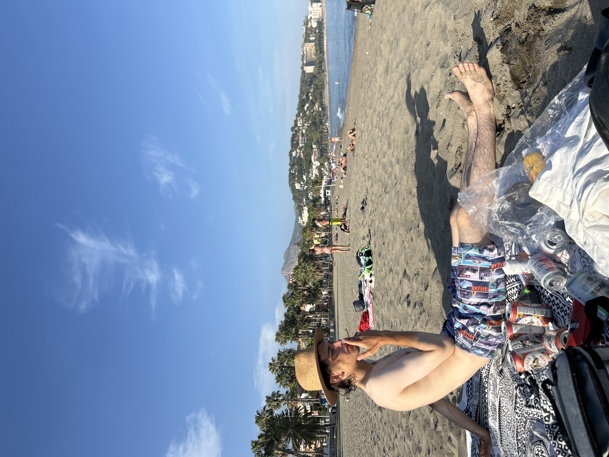 Beachgoers relax, socialize on Málaga coast during summer afternoon