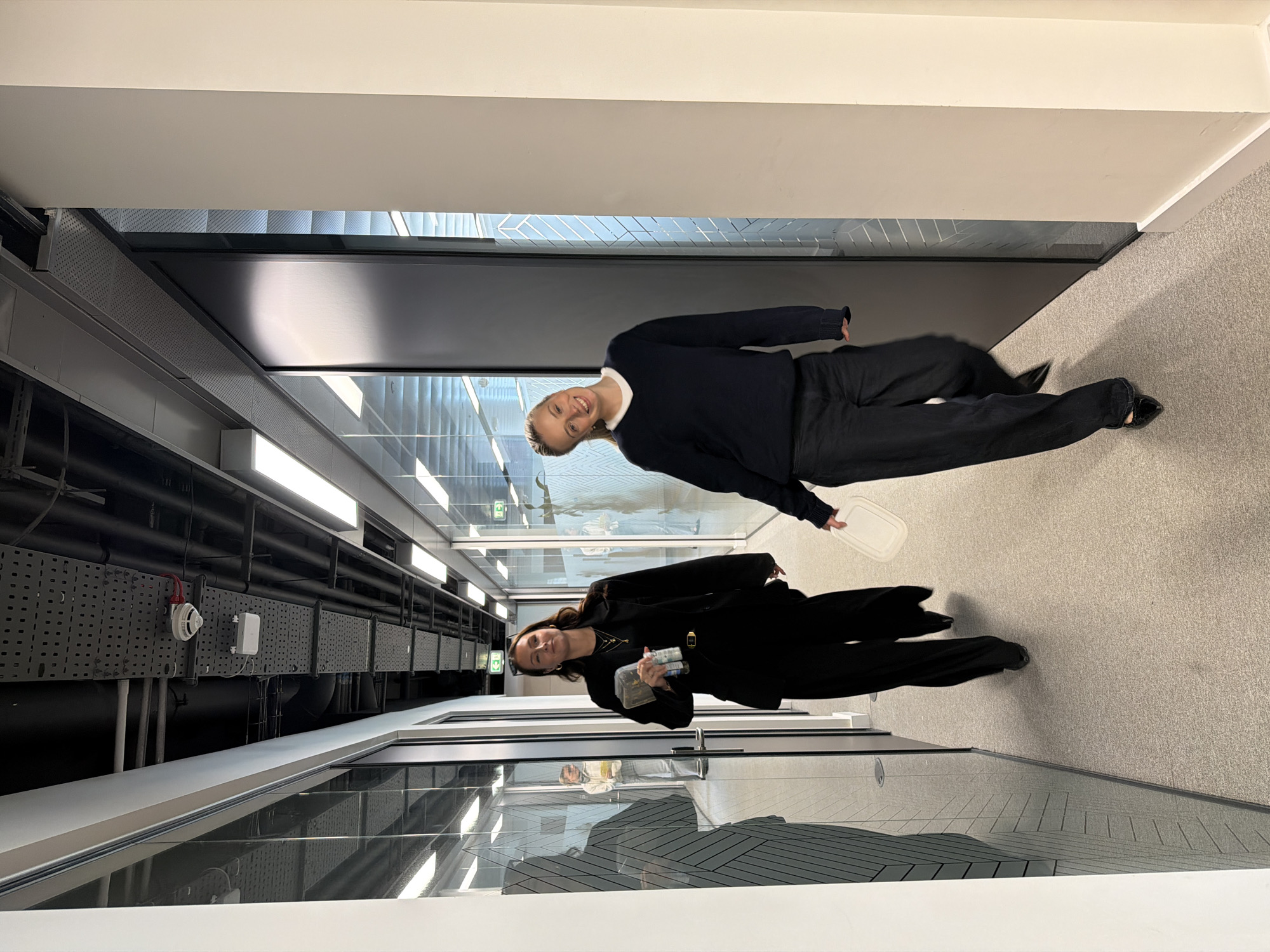 Two women photographed moving through London office building