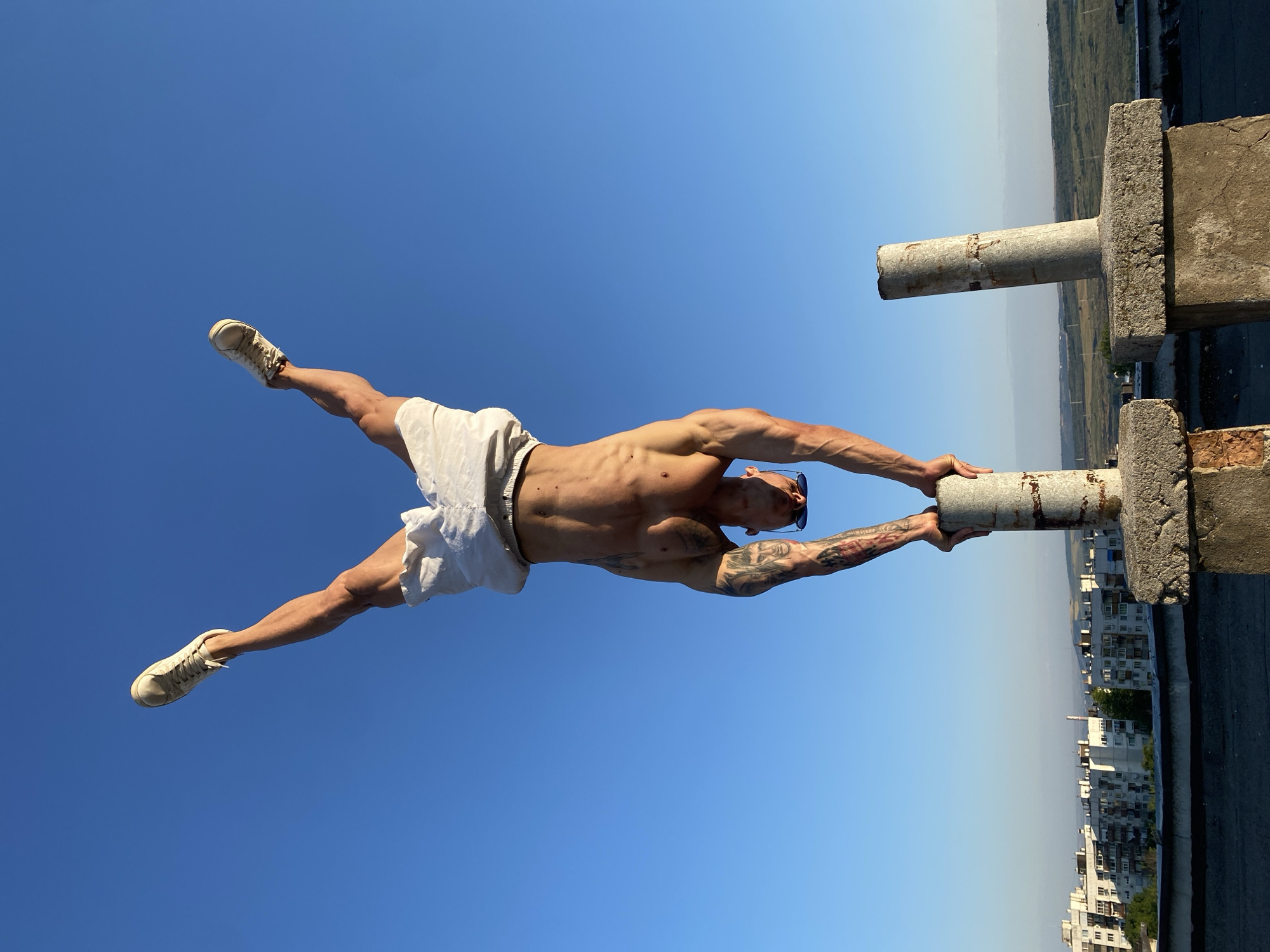 Rooftop handstand on concrete pillars under open sky, Pleven