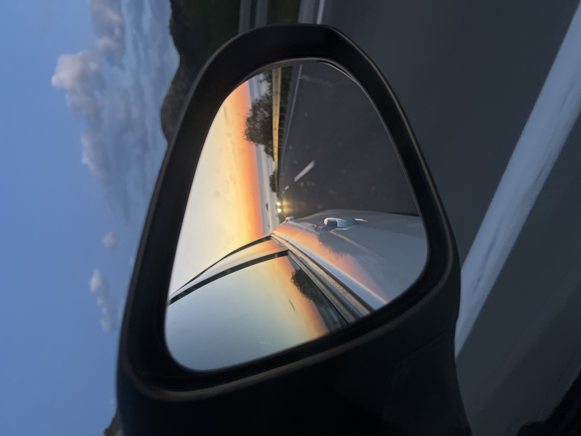 Driver captures sunset reflection in mirror while traveling Montenegro