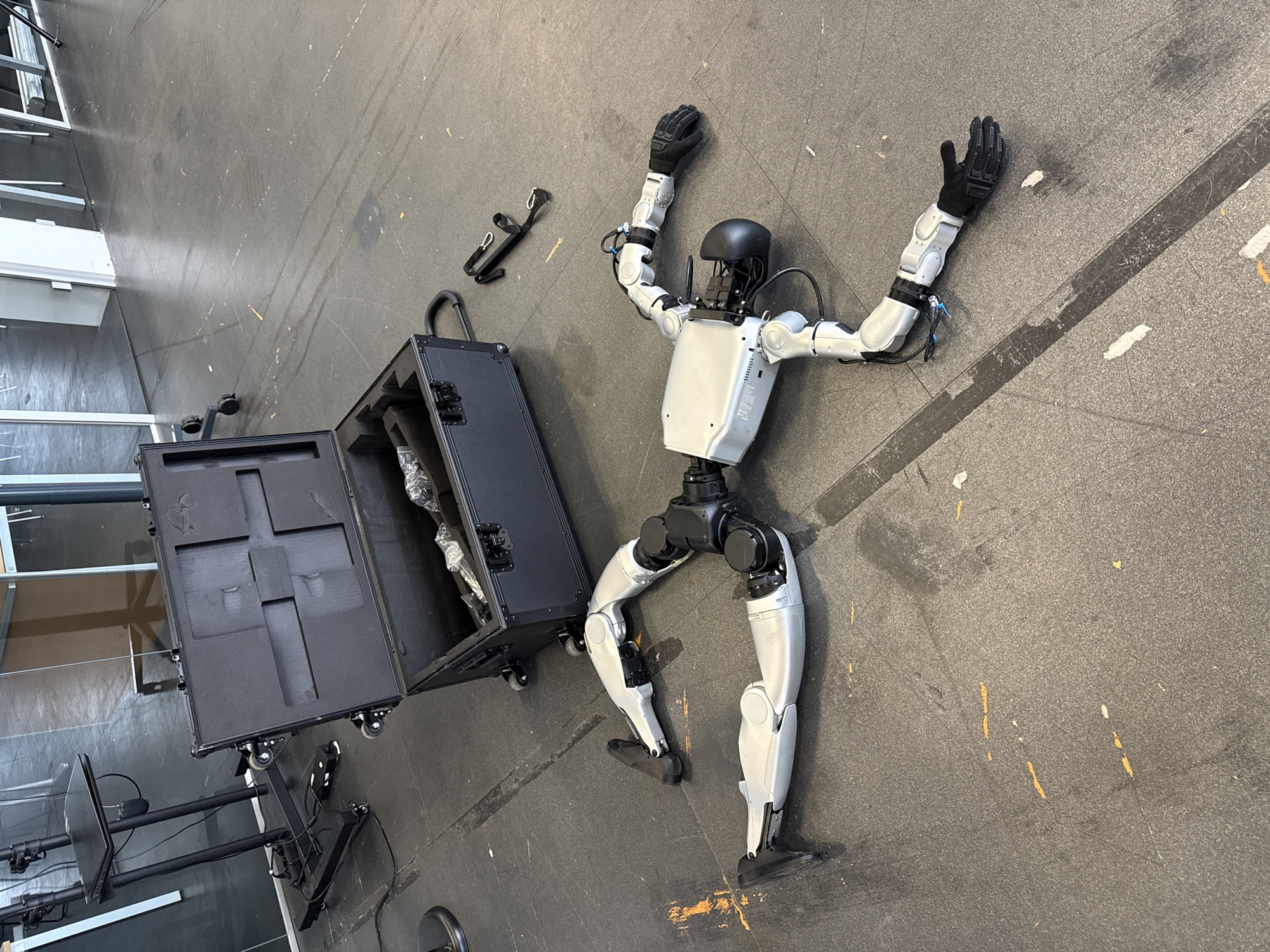 Humanoid robot found motionless on floor, arms splayed