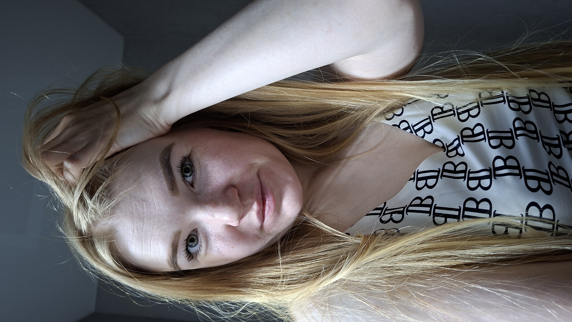 Woman in branded white shirt photographed indoors in Chaikovsky
