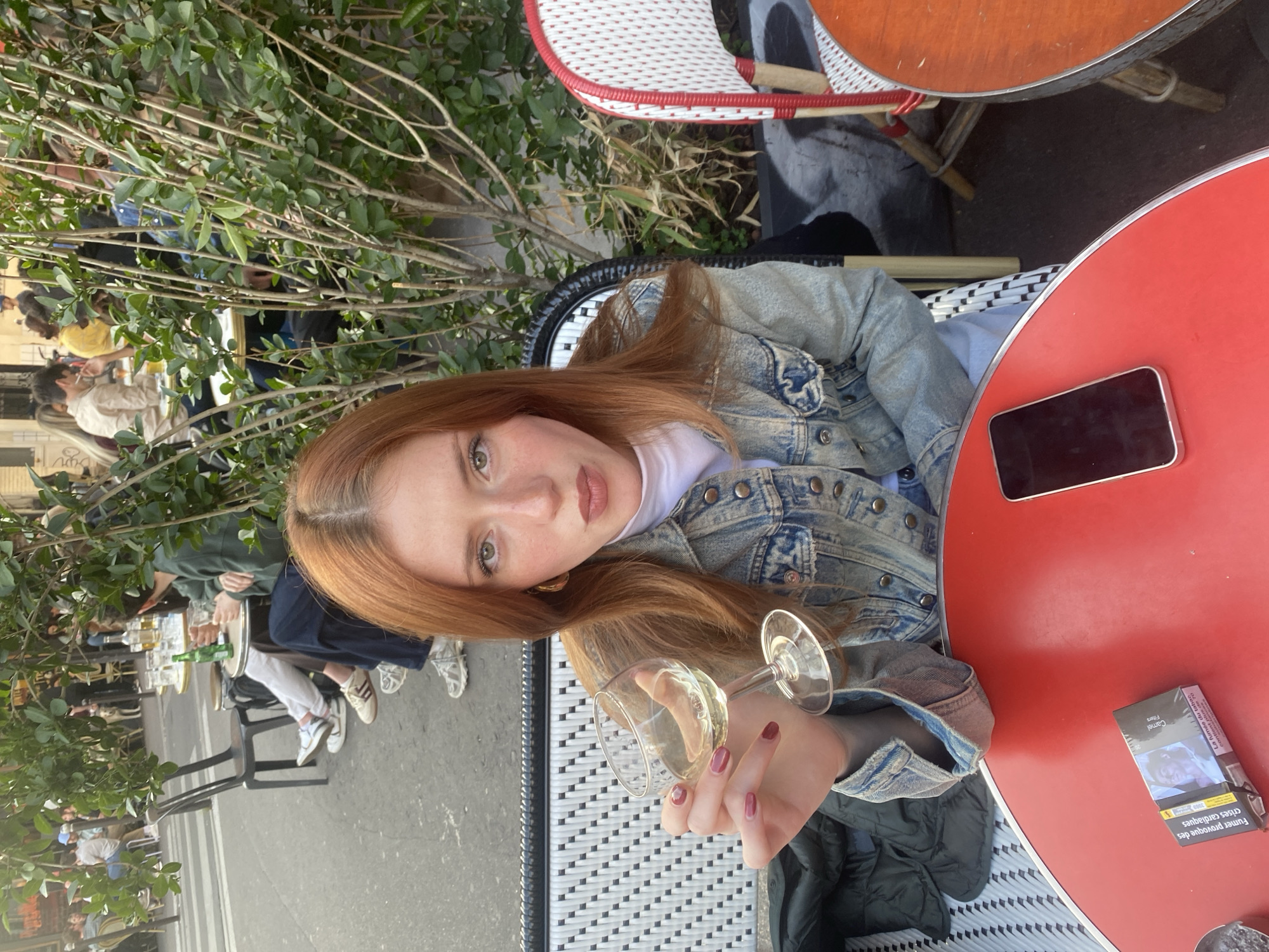 Woman enjoys wine at Paris cafe during evening hours
