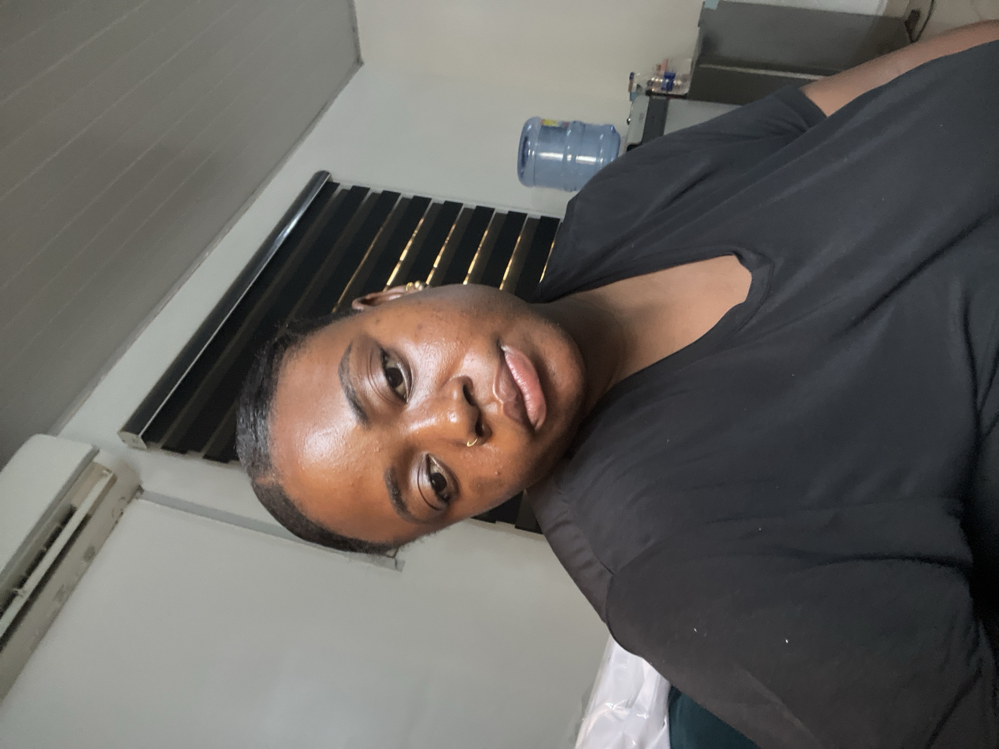 Woman with gold piercings photographed indoors in Abuja