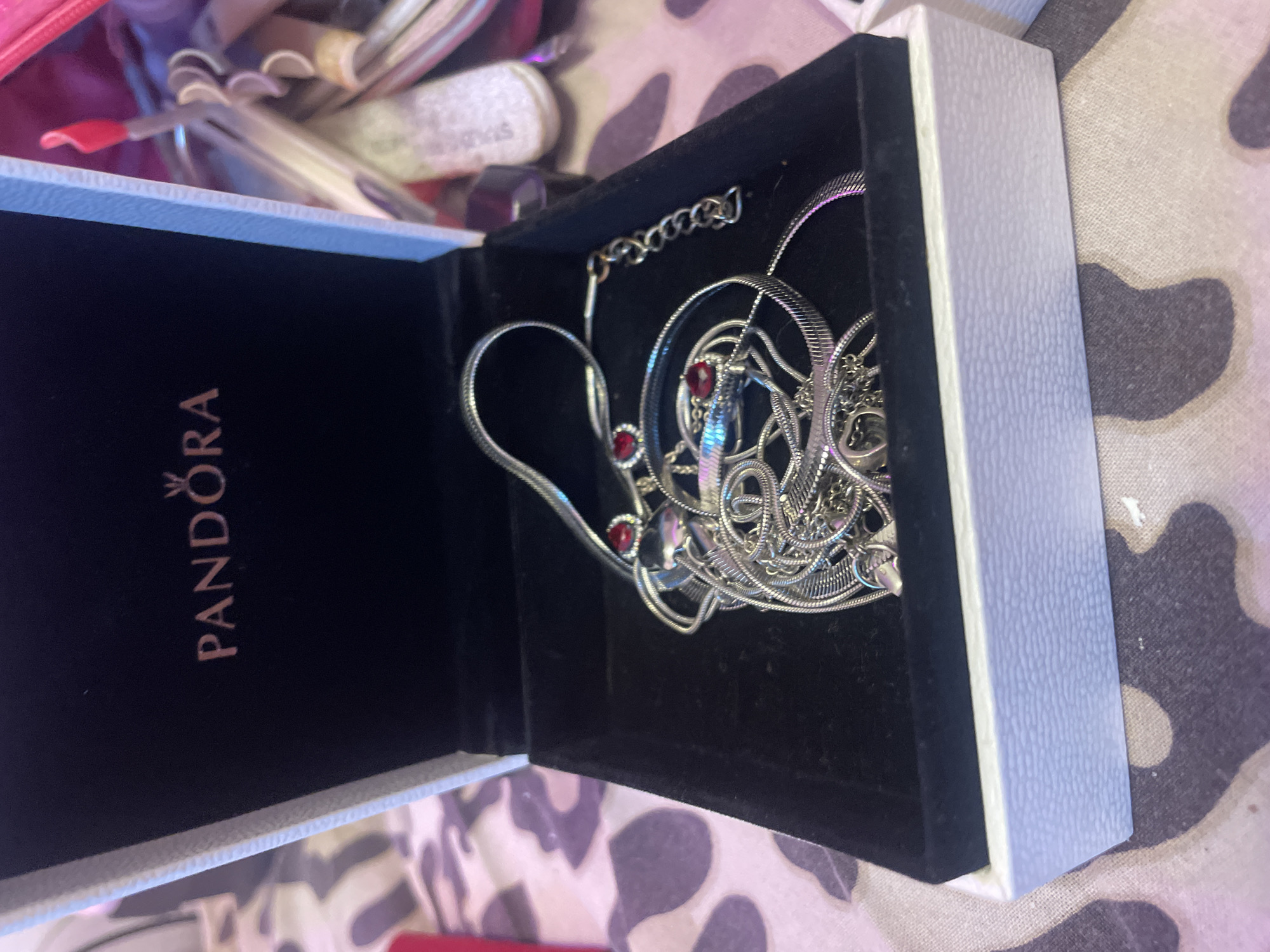 Person examines silver jewelry collection from Pandora box in Russia