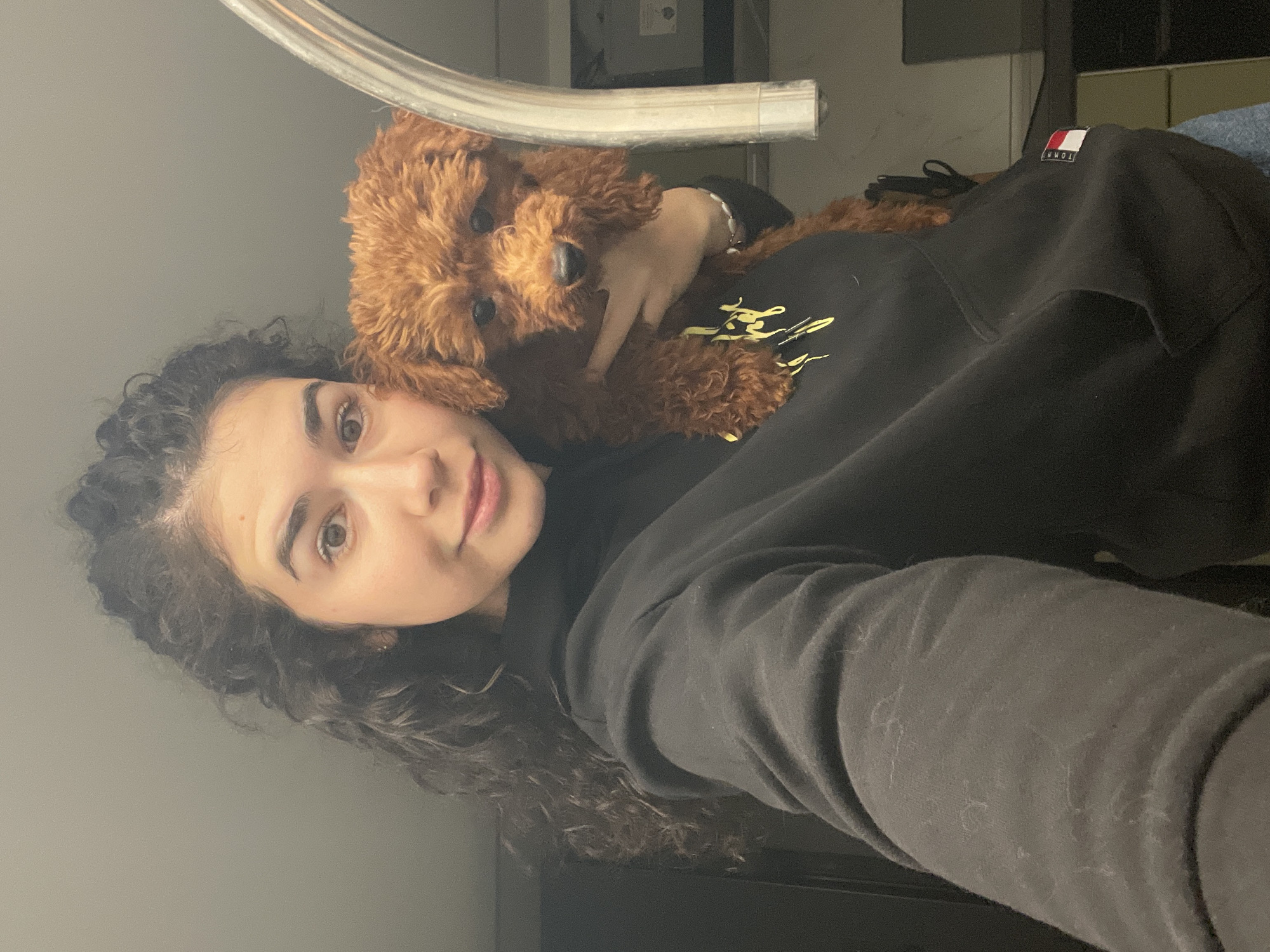 Woman poses with small brown poodle in Sofia apartment