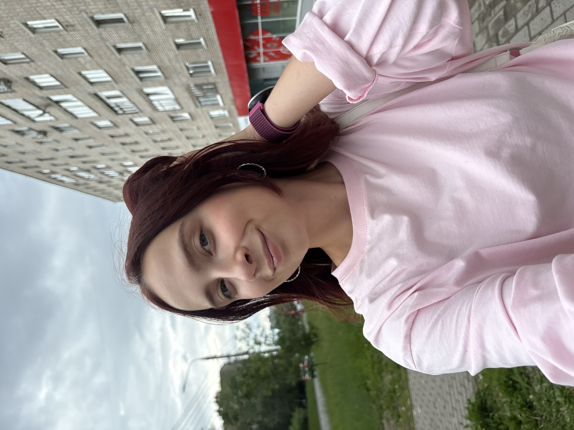 Young women take selfies on cobblestone street in Izhevsk