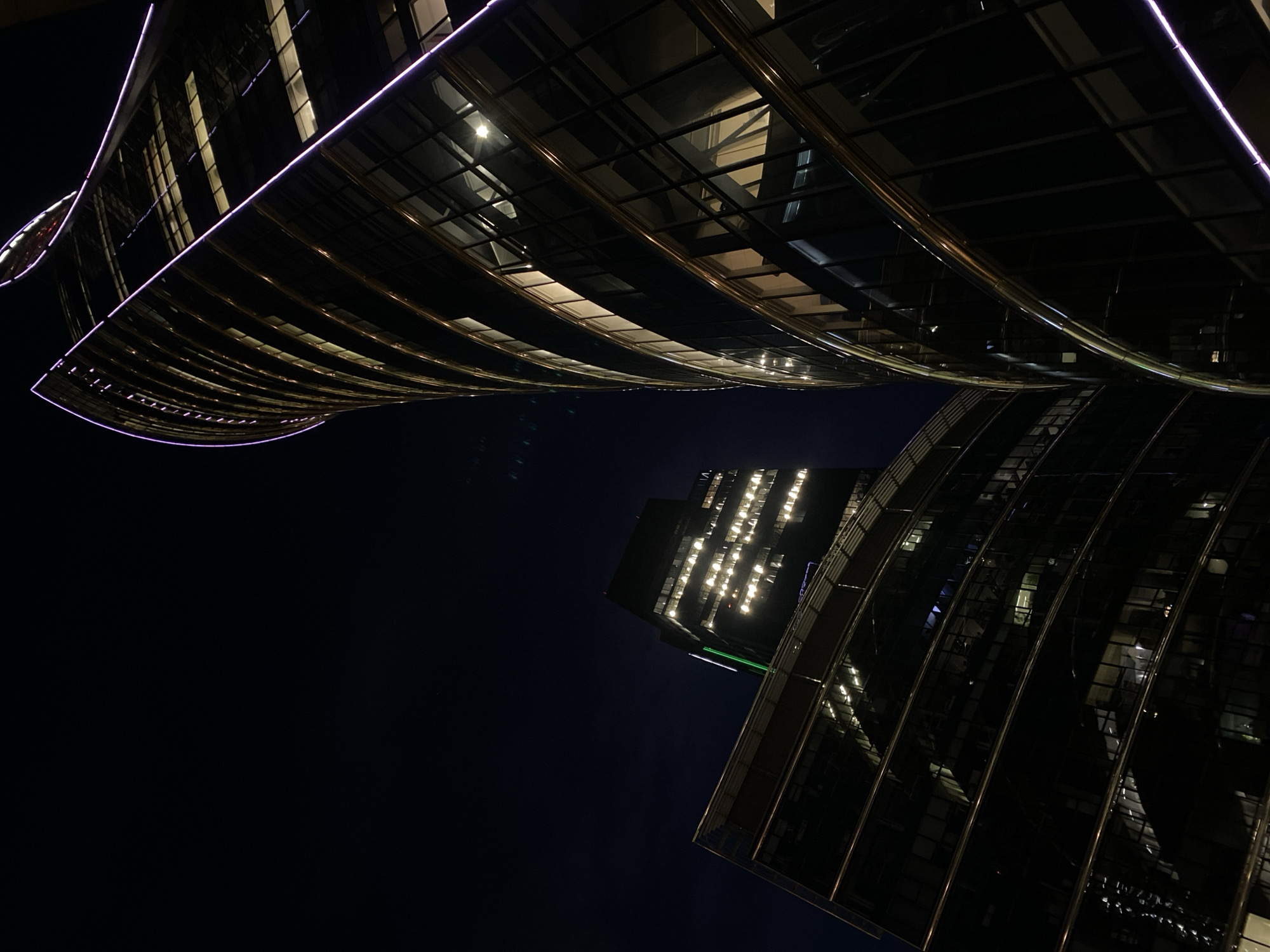 Warsaw's twisting glass towers glow against the night sky
