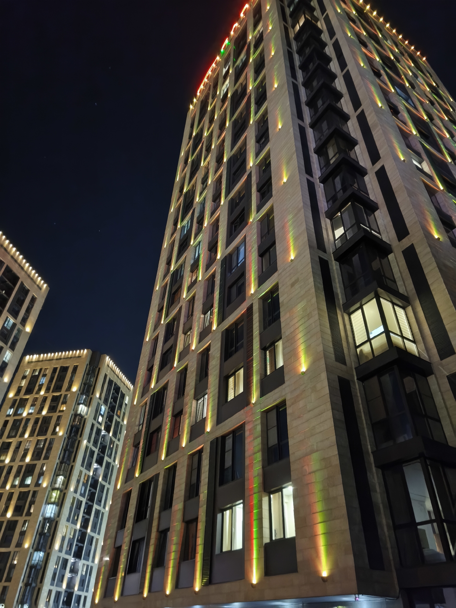 Almaty's lit-up urban core at night, streets and towers