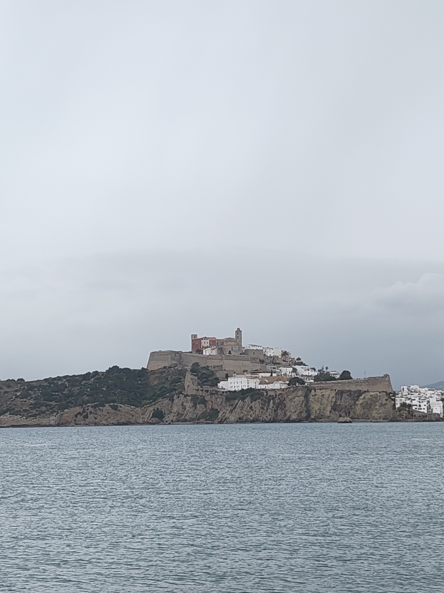 Coastal views of historic Ibiza and docked sailboat captured