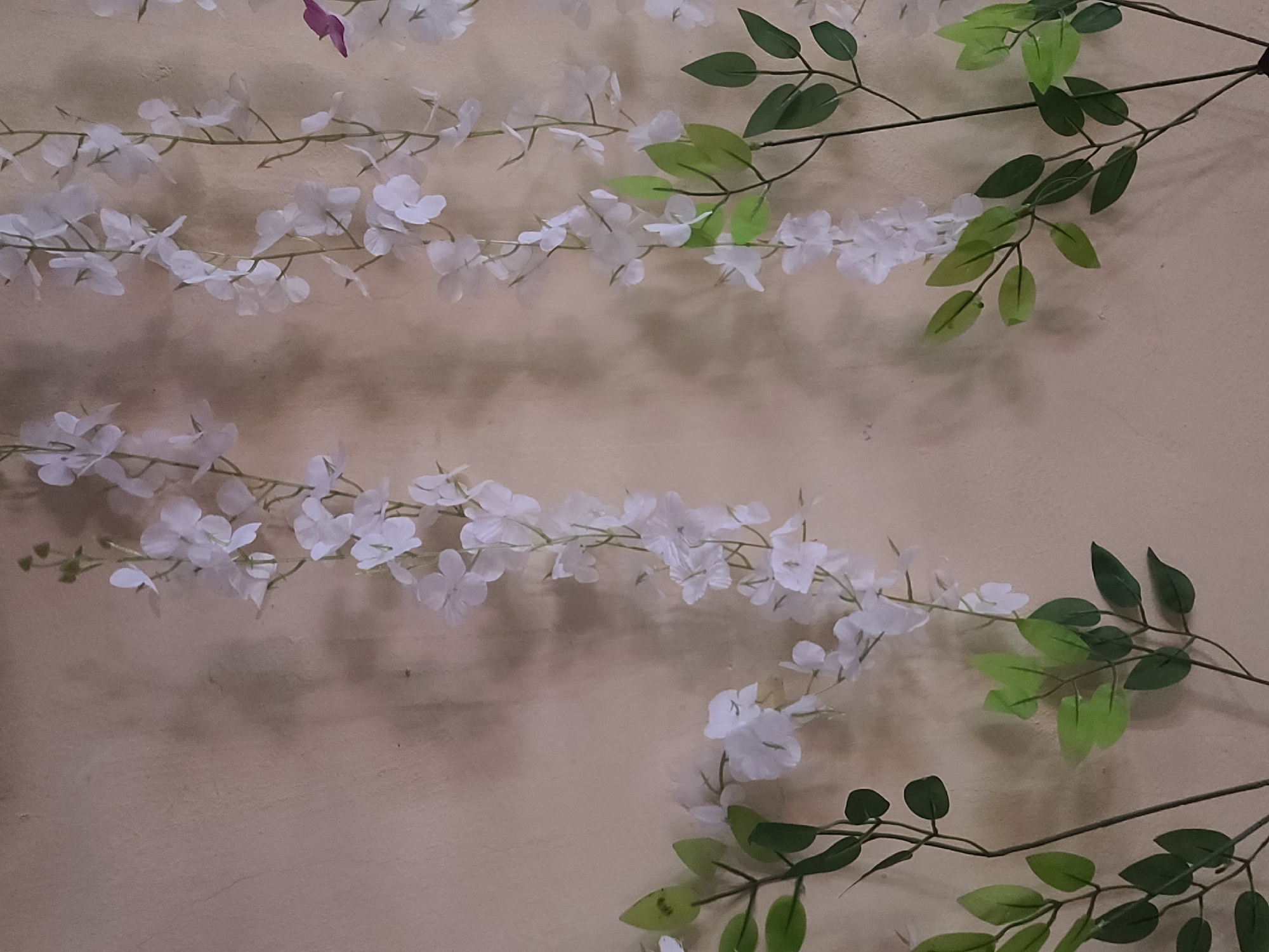 Artificial flower garlands displayed on wall in Nyeri