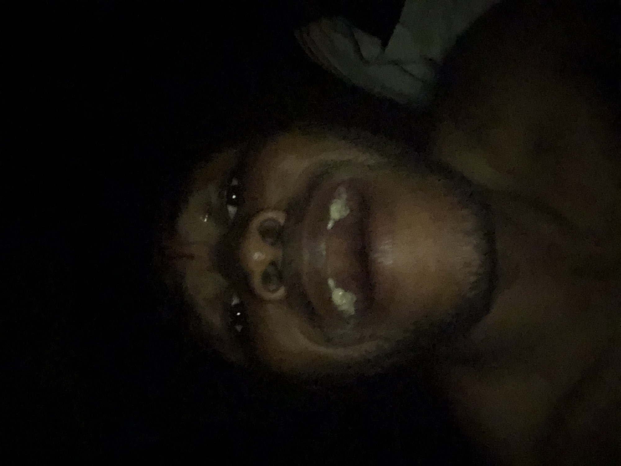 Man photographed making animated expressions in low-light selfie session