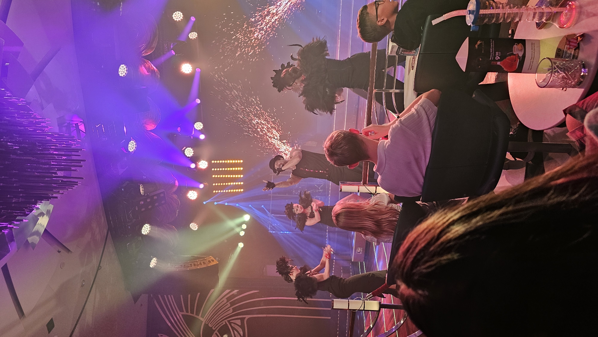 Four performers on a pyrotechnic-lit stage, mid-show.