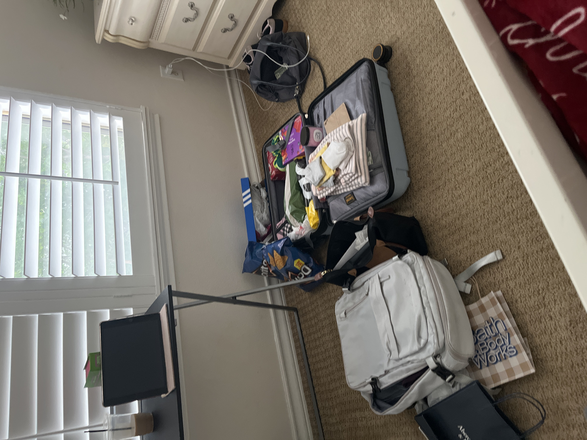 Woman uses phone in cluttered San Antonio bedroom