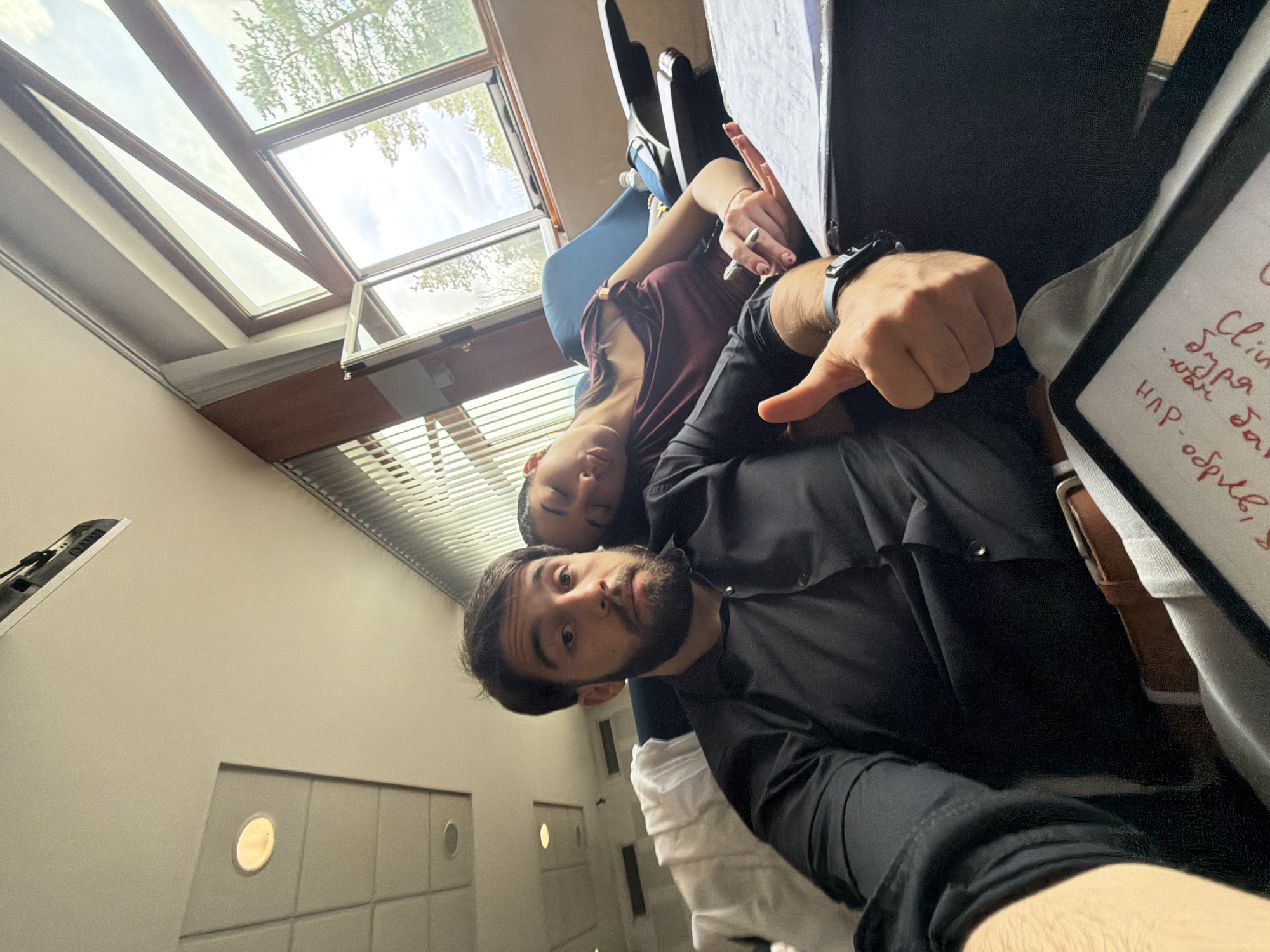 Two people photographed indoors with notepad in Sofia