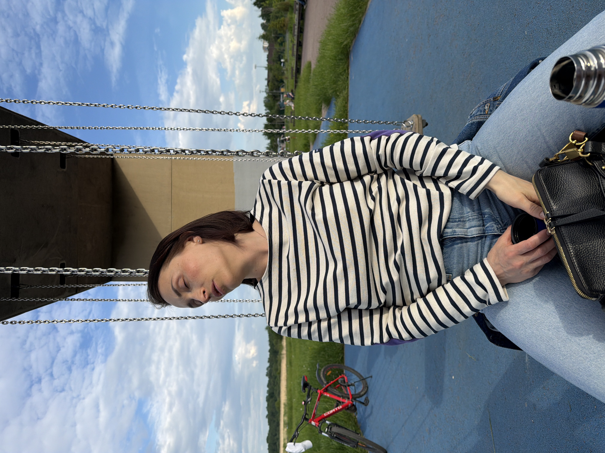 Woman rests peacefully on outdoor swing in Strelna, Russia
