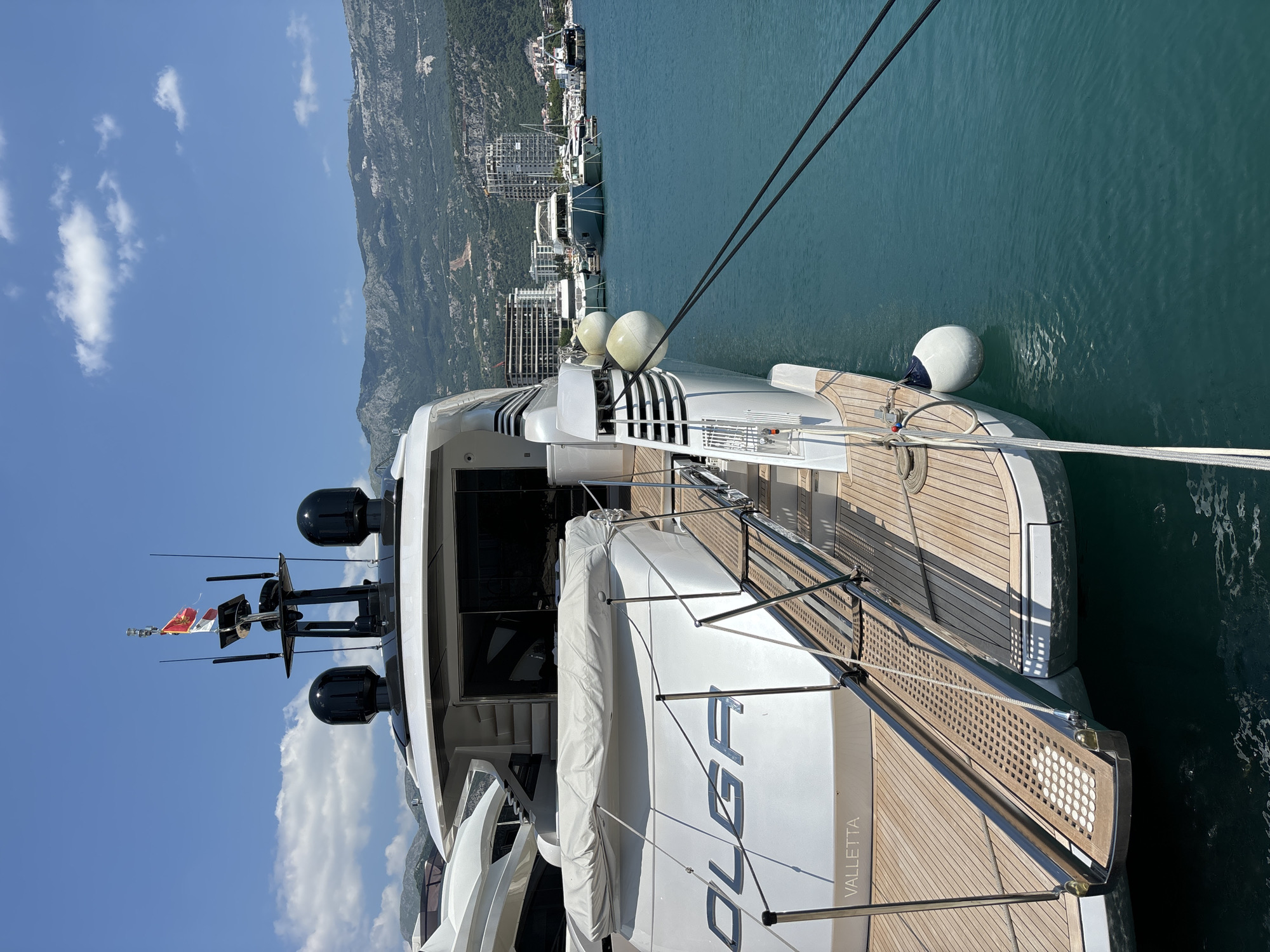 A busy morning at Budva's marina — yachts, cranes, and promenade life.