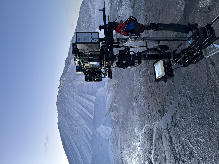 Film crew captures snowy mountain landscape at dawn