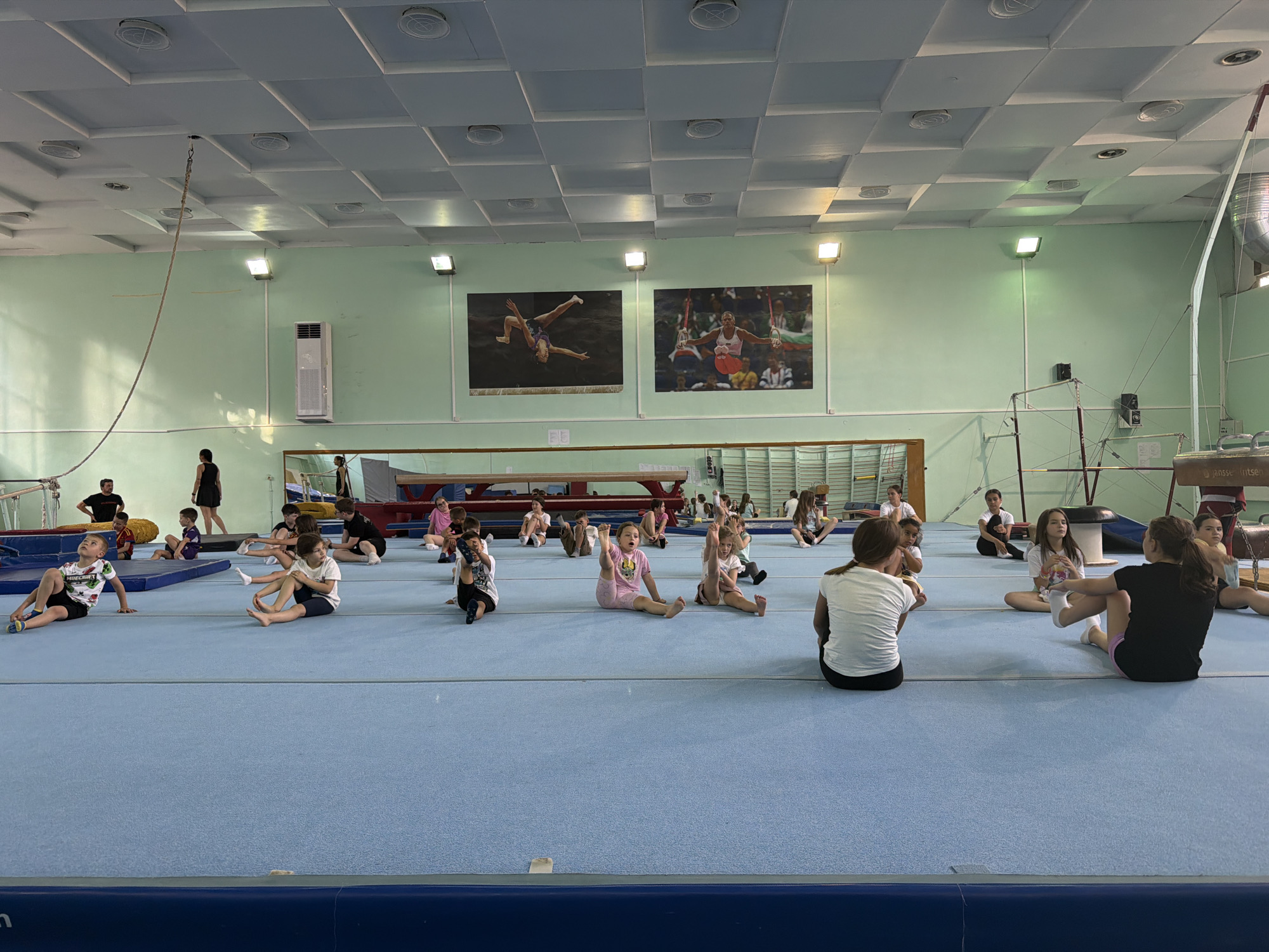 Gym scene with children, tattooed man's selfie captured separately