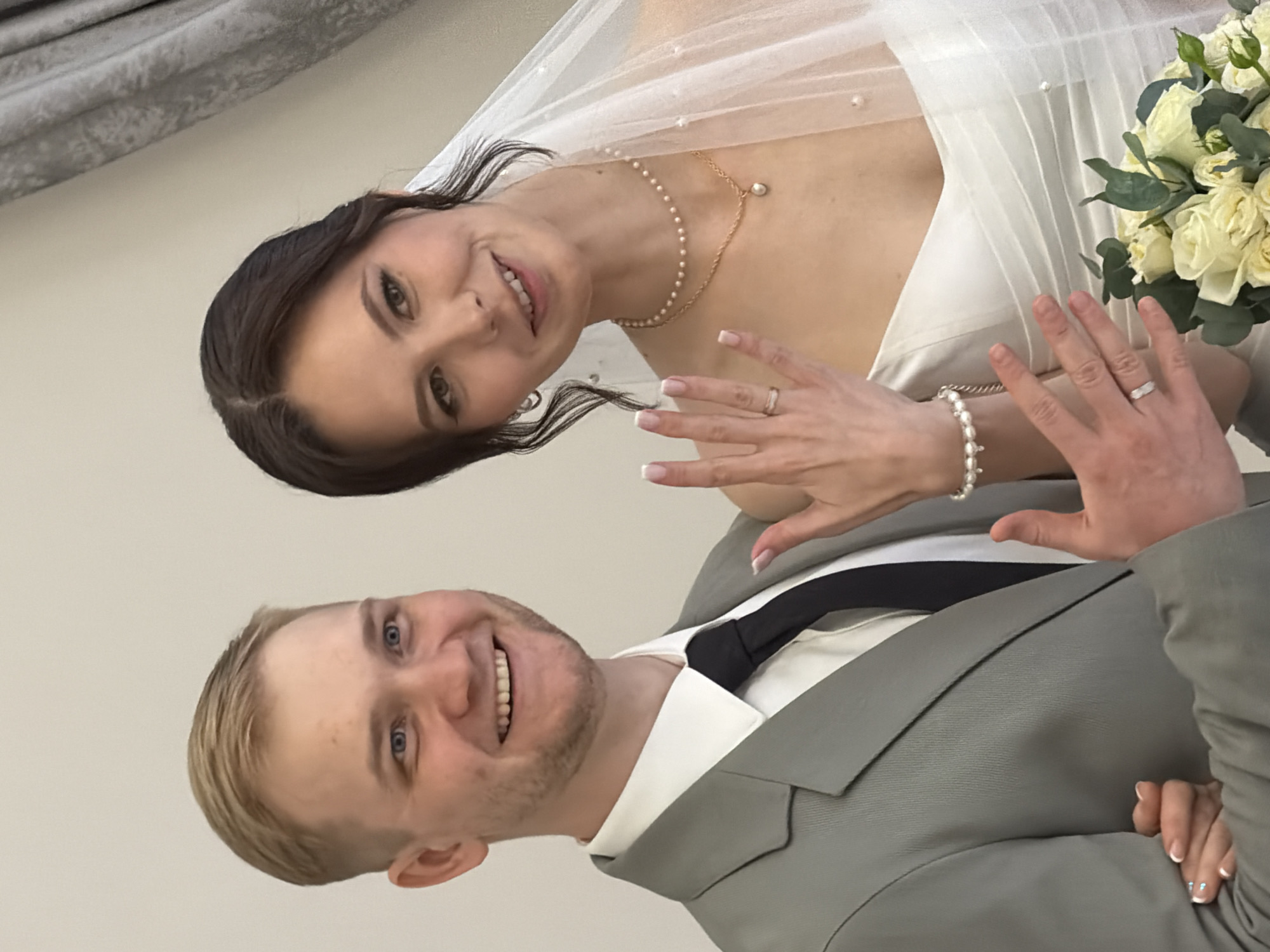 Couple dressed in wedding attire poses together
