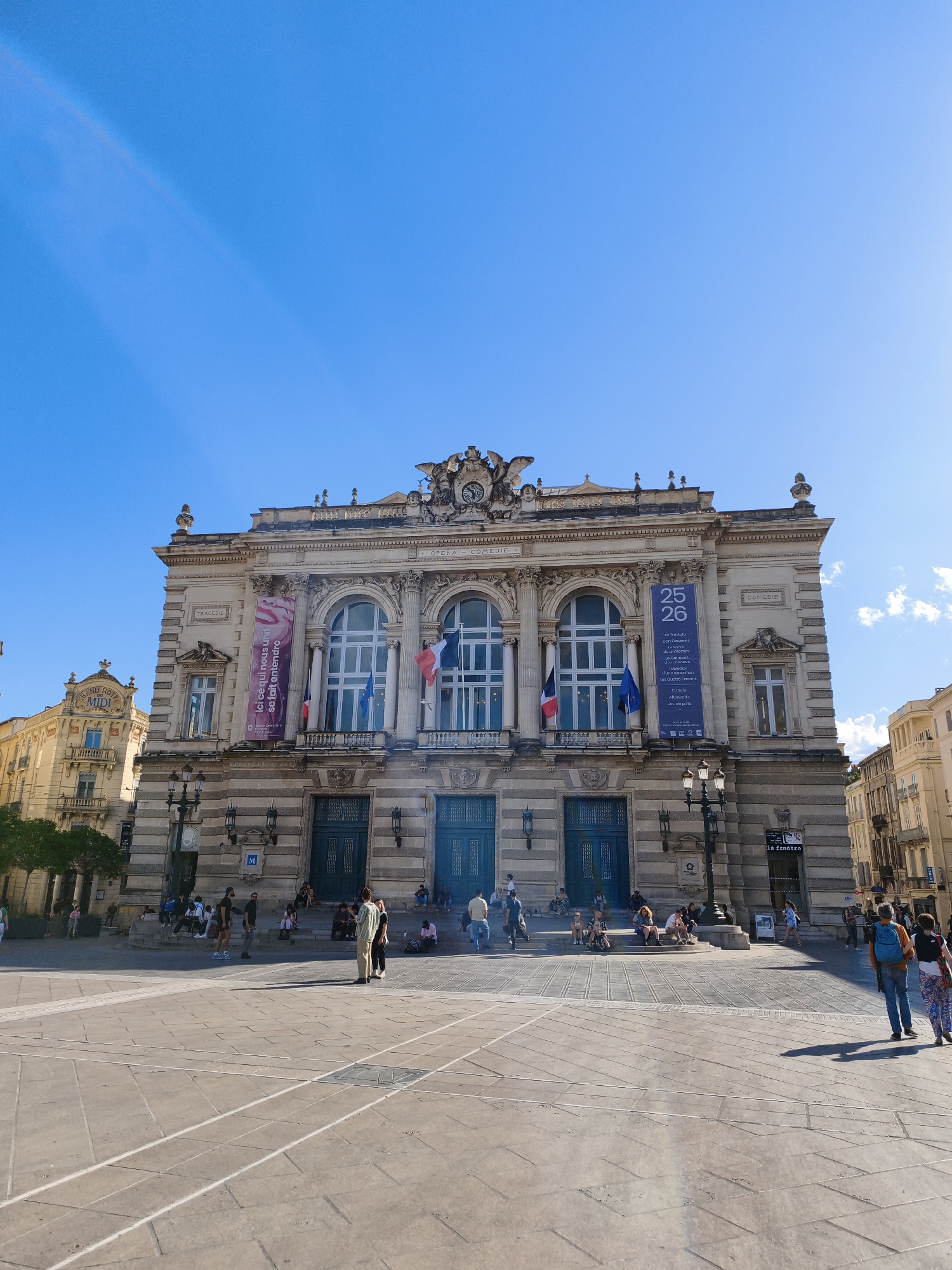 Theater displays French flags from arched windows in Montpellier