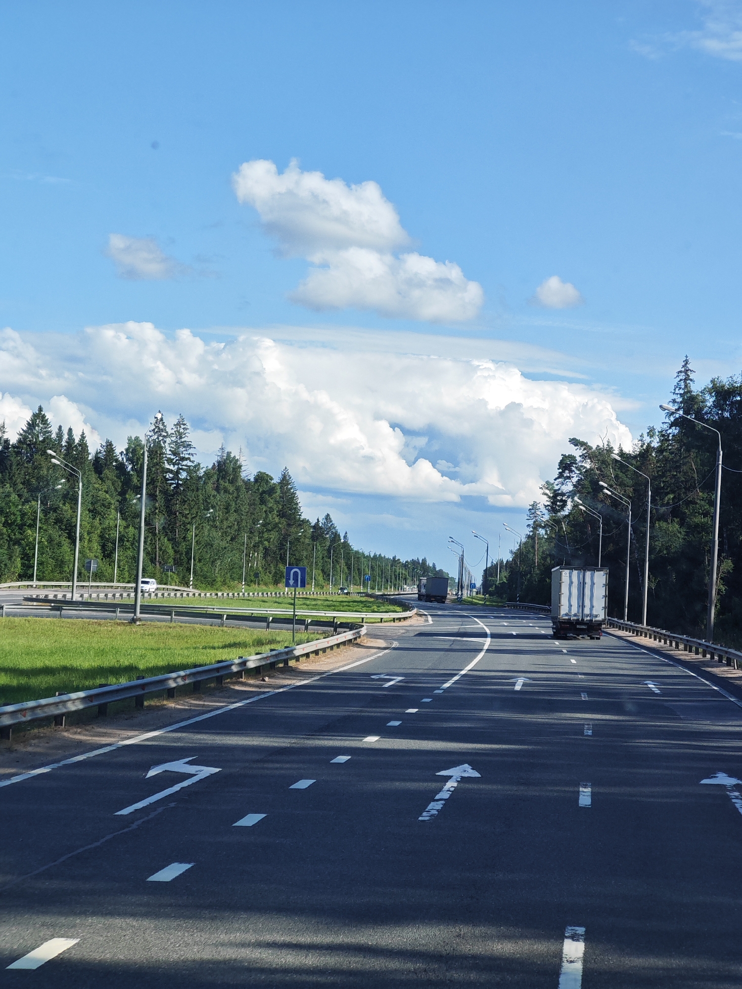 Multi-lane highway cuts through Kuzhlevo under summer skies