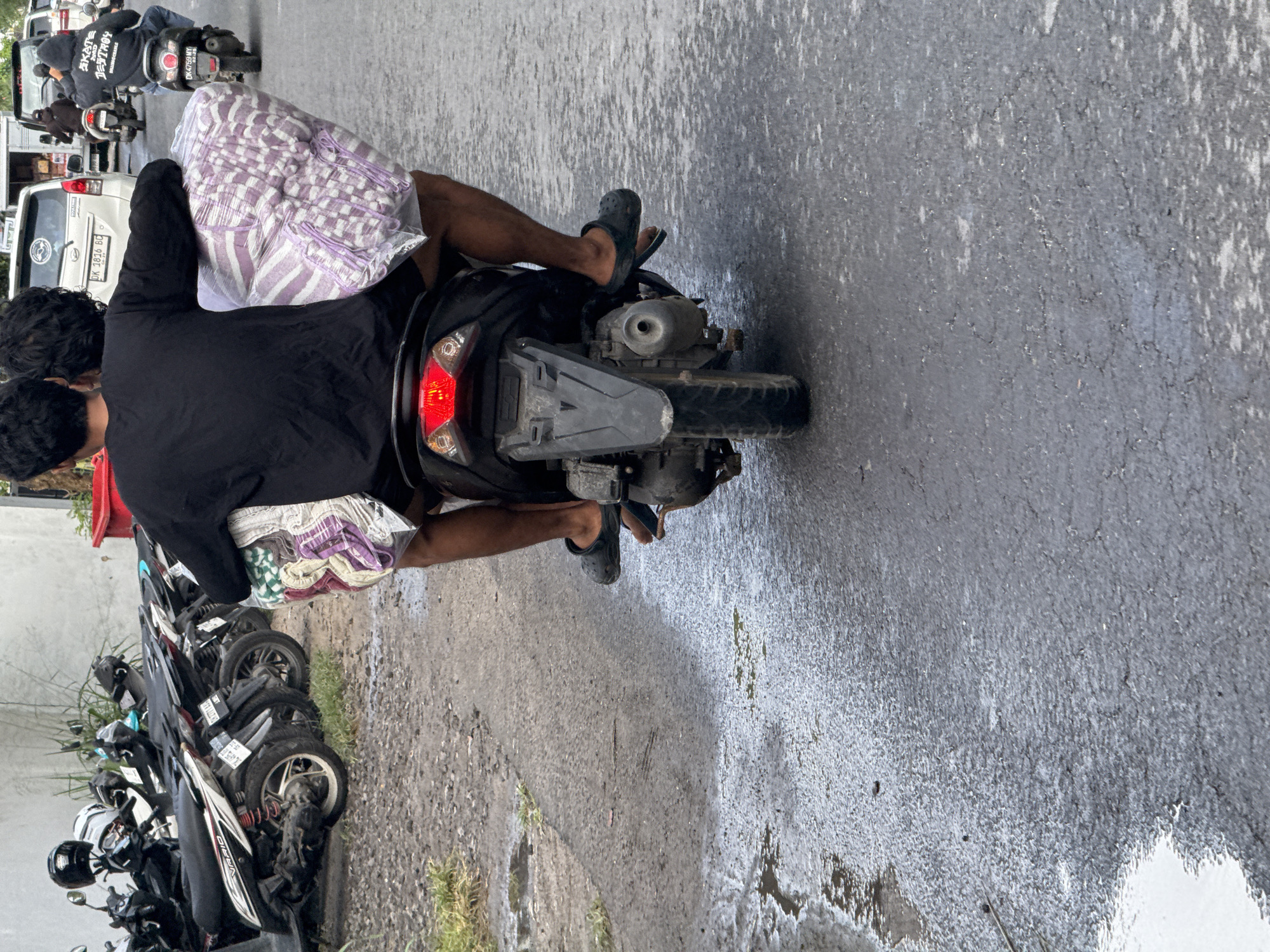 Motorcyclist travels road in Nusa Penida carrying package