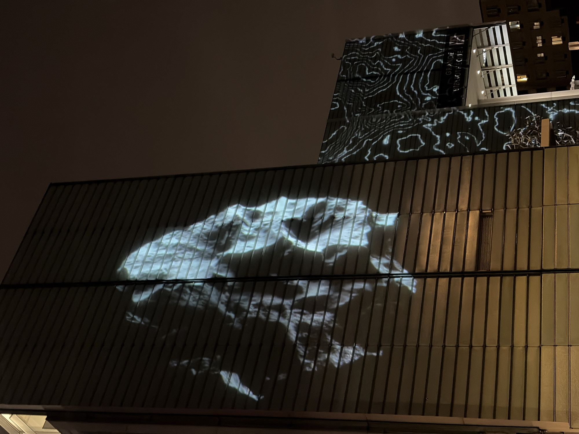 Light projections illuminate Montreal buildings near Grande Bibliothèque