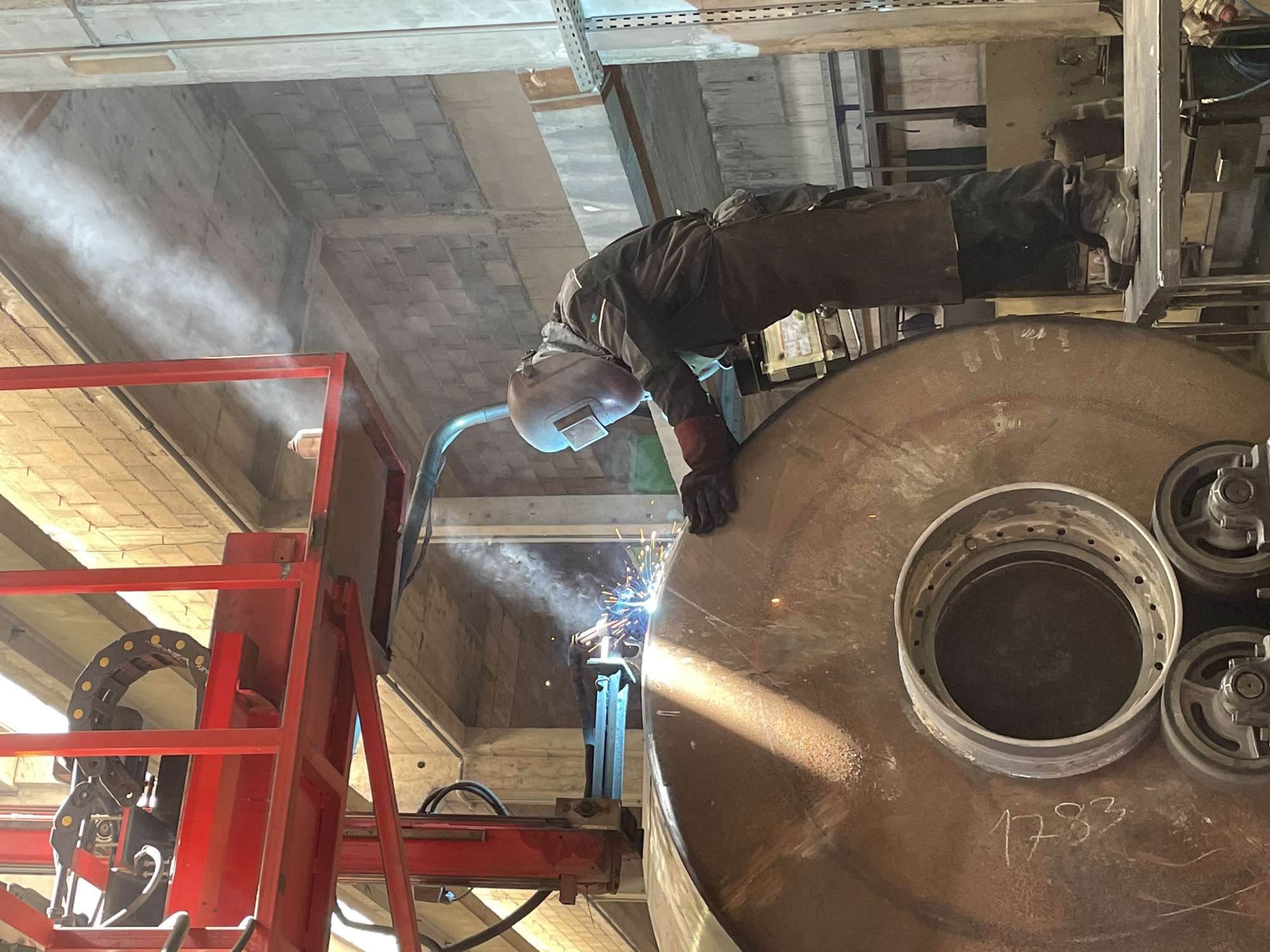 Welder works on metal cylinder in Montenegro industrial facility