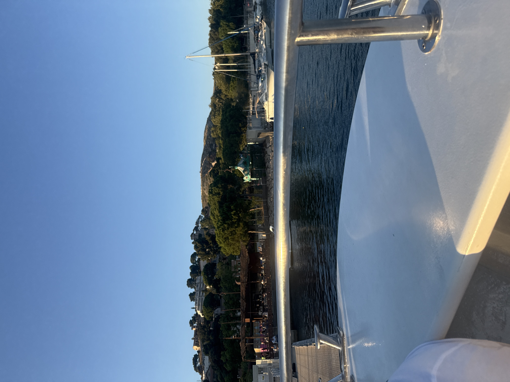 Boat ride through calm harbor waters on a sunny afternoon