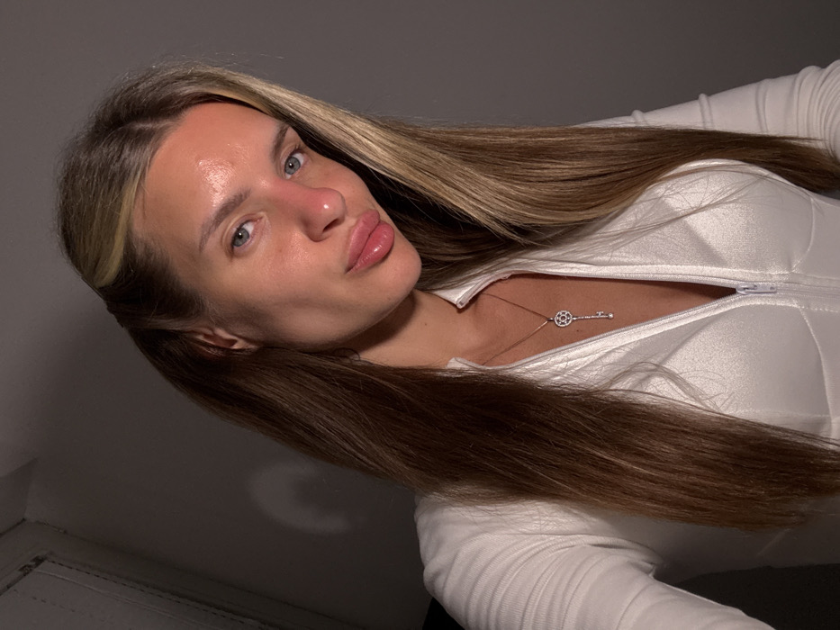Woman takes selfies in Berlin bathroom wearing white jumpsuit