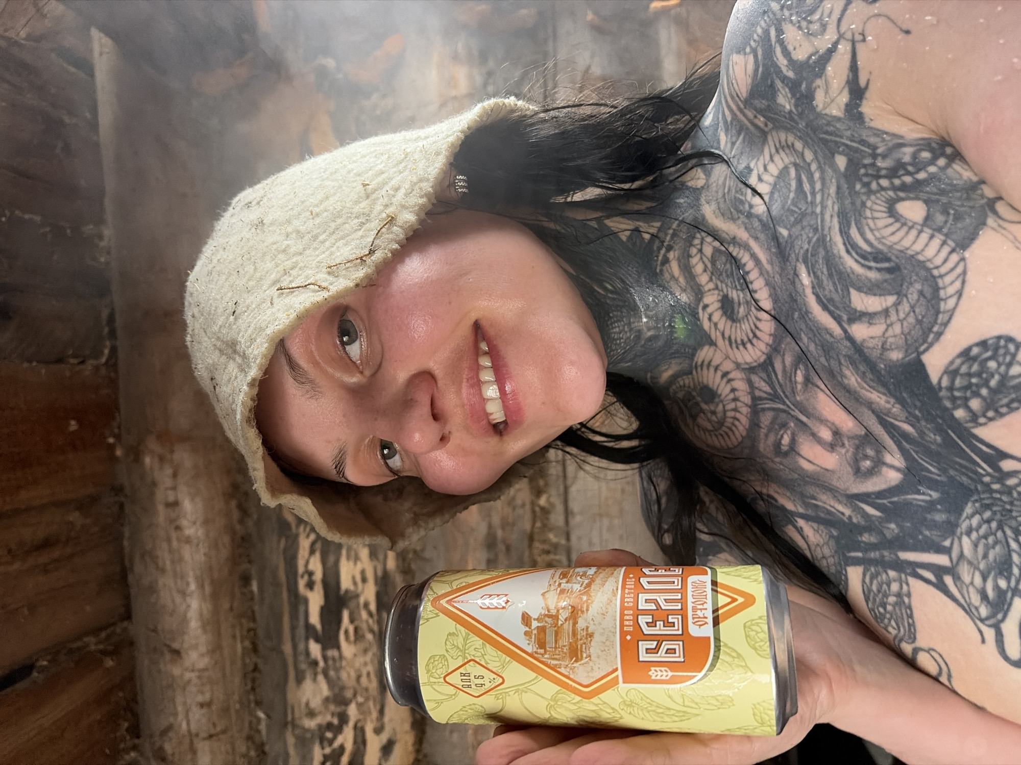 Person with tattoos holds beer in Russian town