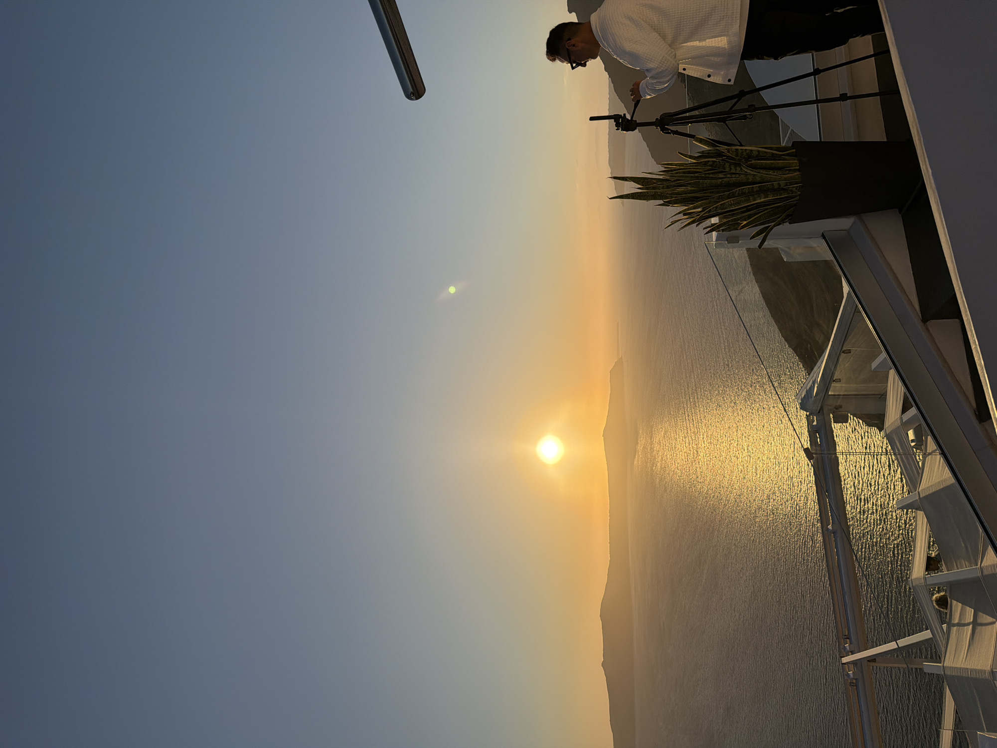 Tourist captures sunset and local shops during Santorini afternoon visit