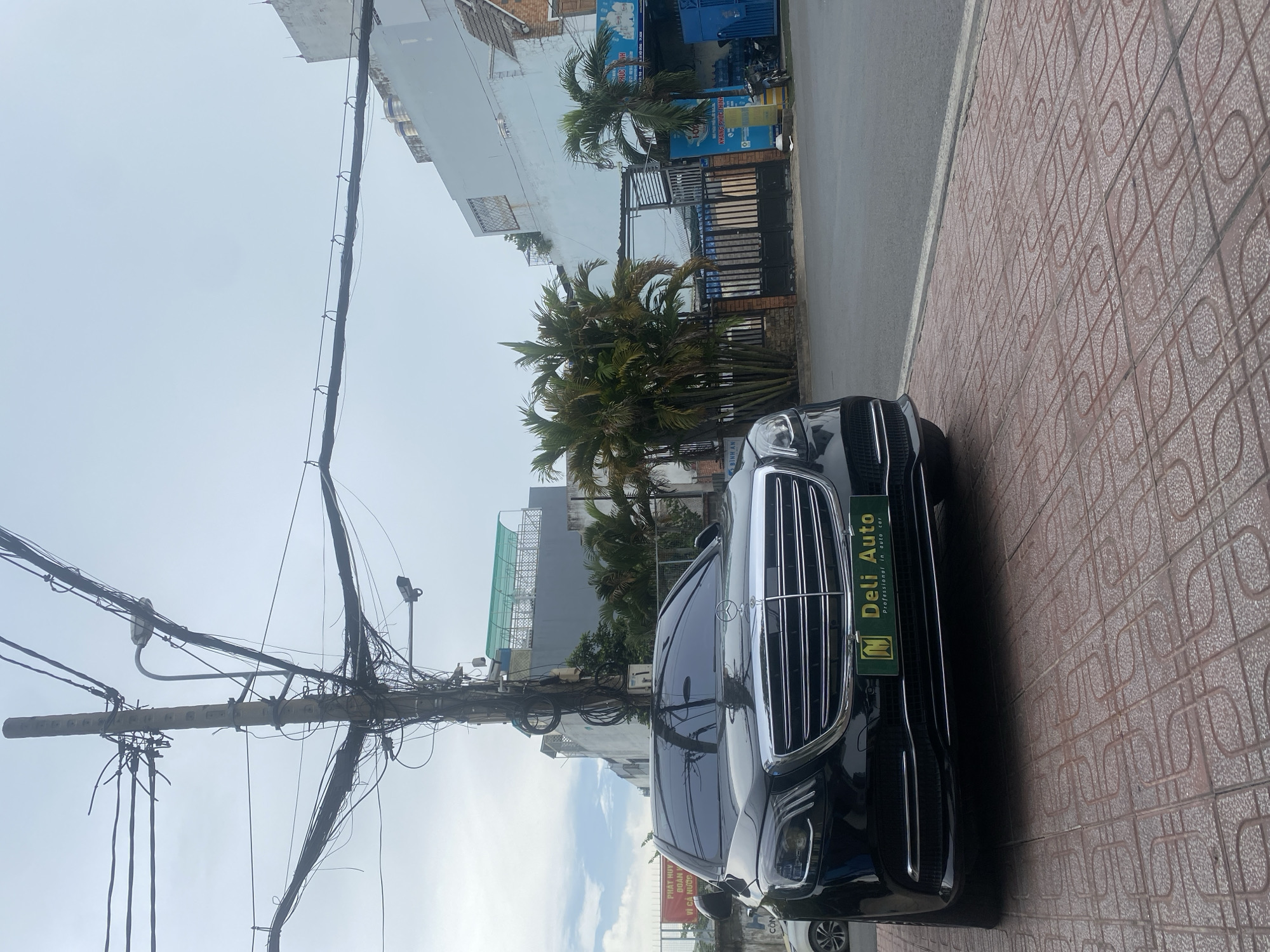 Luxury cars and everyday riders share a Thuận An street