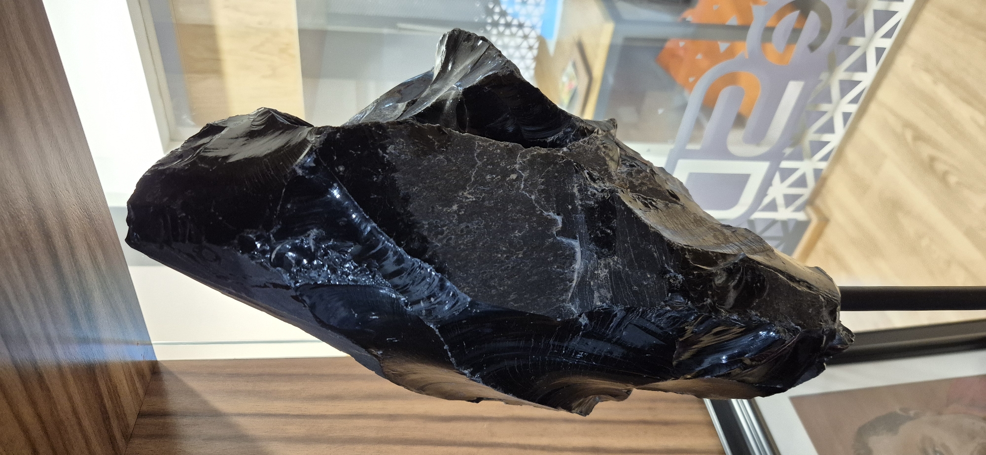 Large obsidian specimen observed on wooden shelf in Mexico City