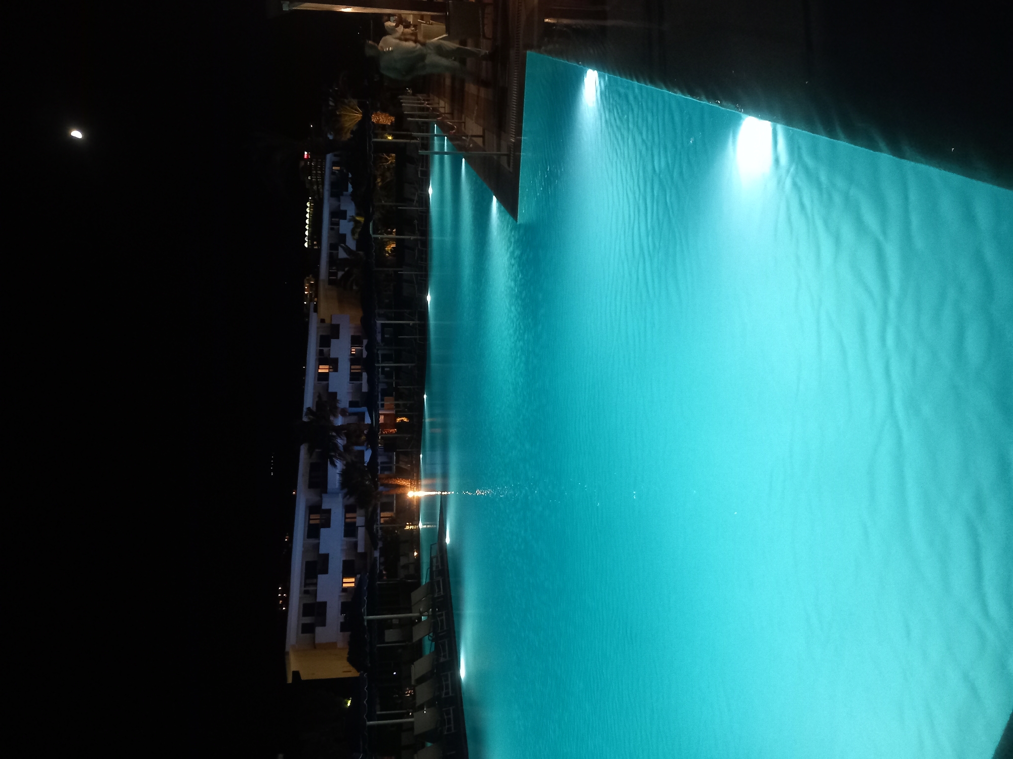 Resort evening in Kos: pool lights, palm trees, live music