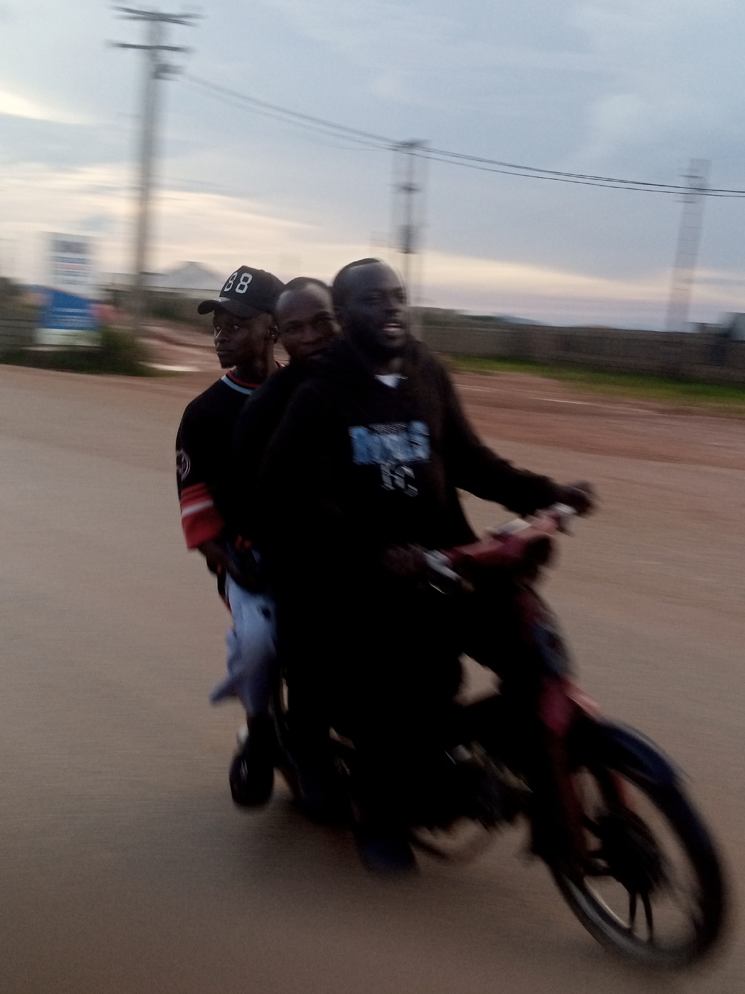 Storm clouds gather over Jos as a motorcycle moves through the streets