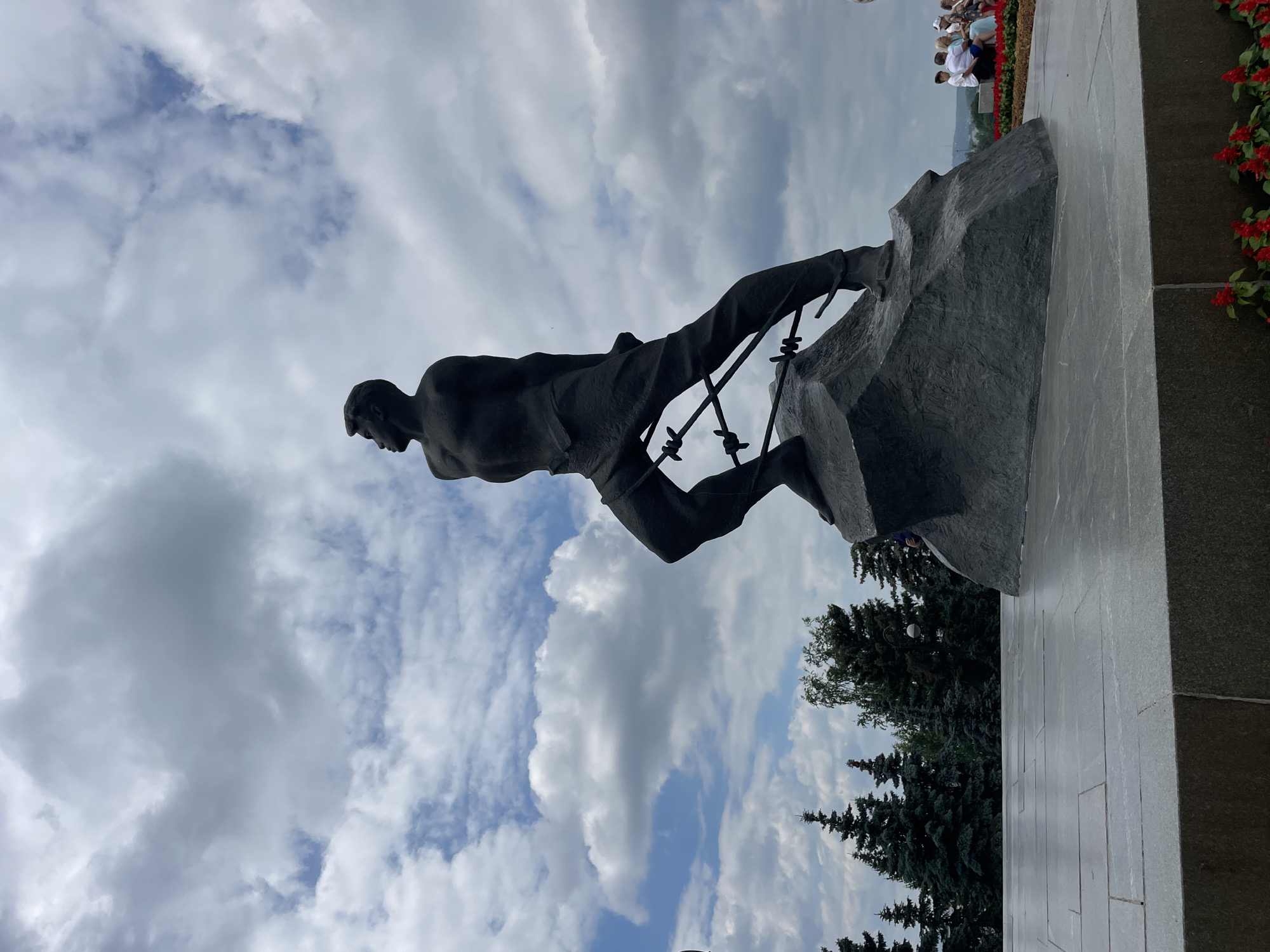 Bronze statue shows struggling figure on jagged rock